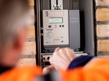 Man looking at an installed Kamstrup electricity meter.