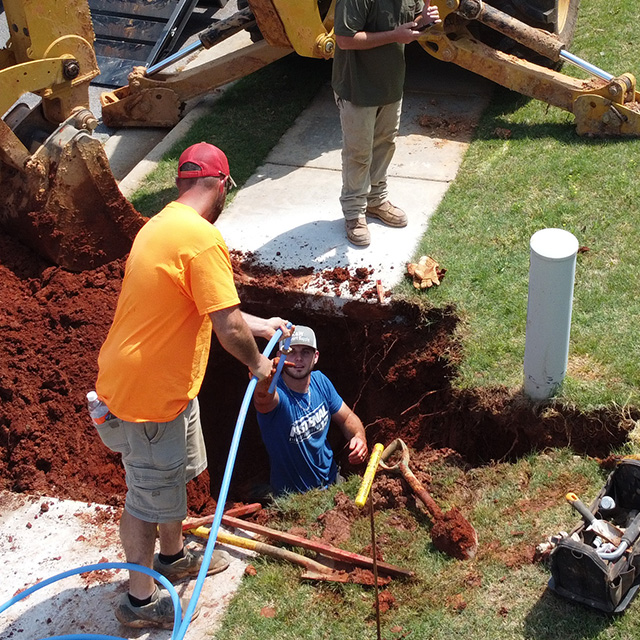people digging a whole to fix a leaking water pipe